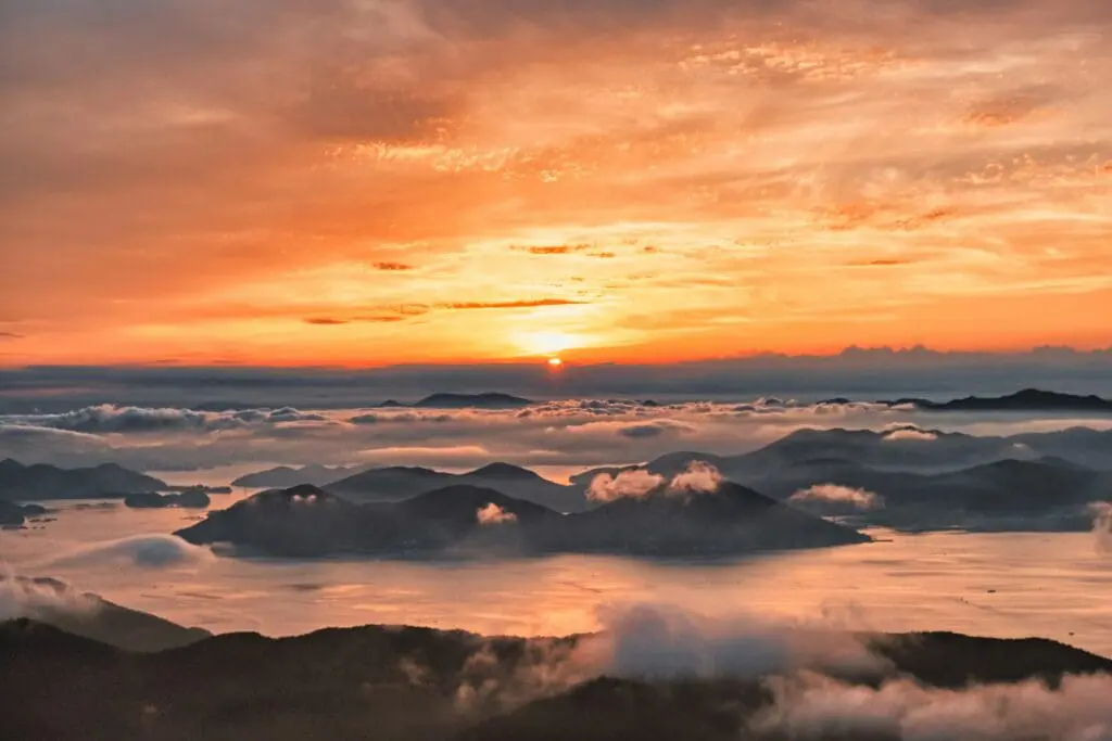 Sunset over the mountain tops above the clouds.